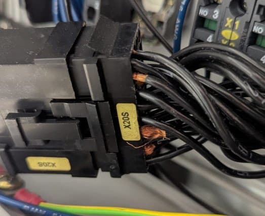 Extremos de cable con los hilos de cobre desnudos a la vista en un conector sin terminar